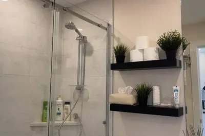 a bathroom with a shower with a glass door at Modern Spacious 1BR minutes away from Main St in Vancouver