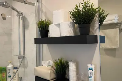 a bathroom with a shelf with toilet paper and plants at Modern Spacious 1BR minutes away from Main St in Vancouver