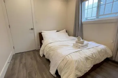 a bedroom with a bed with a teddy bear on it at Modern Spacious 1BR minutes away from Main St in Vancouver