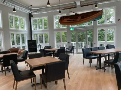 a restaurant with tables and chairs and a boat hanging from the ceiling at Baymont by Wyndham Gold River in Gold River