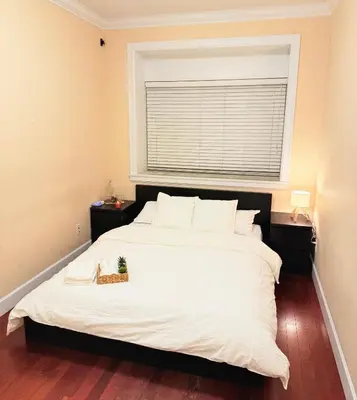 a bedroom with a large white bed with a window at Modern & Cozy 2-Bed Suite in Vancouver in Vancouver