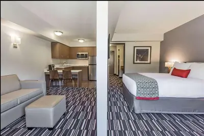 a hotel room with a bed and a kitchen at Microtel Inn & Suites by Wyndham Fort Saint John in Fort Saint John