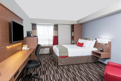 a hotel room with a bed and a desk and a tv at Microtel Inn & Suites by Wyndham Fort Saint John in Fort Saint John