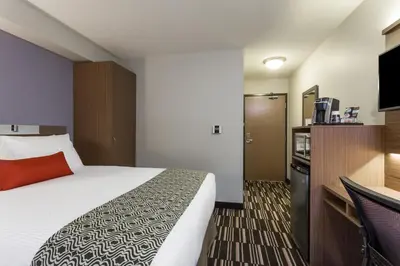 a hotel room with a bed and a kitchen at Microtel Inn & Suites by Wyndham Fort Saint John in Fort Saint John