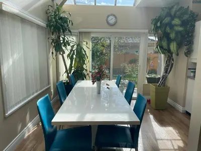 a dining room with a white table and blue chairs at Rose Garden Vancouver Airport - Richmond BC in Richmond