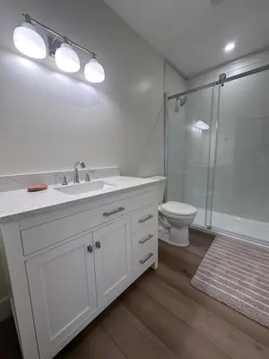 a white bathroom with a sink and a toilet at The Grove B&B Mayne Island in Mayne Island