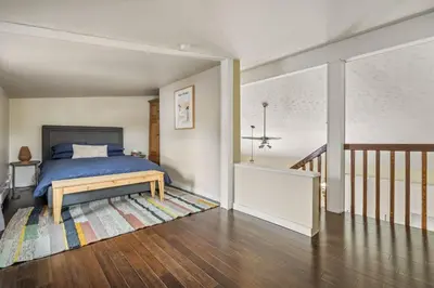 a bedroom with a blue bed and a staircase at Dinos Last Post - Family Friendly 4 Bedrooms in Drumheller