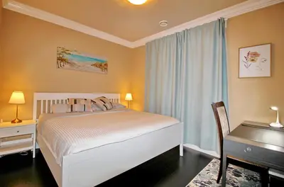 a bedroom with a white bed and a desk and a chair at Close to YVR King Sized Private Entrance Suite in Richmond