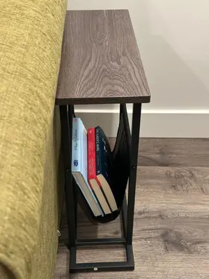 a end table with books on it next to a couch at Juanus Cozy Cove in Edmonton