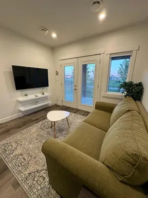 a living room with a couch and a flat screen tv at Juanus Cozy Cove in Edmonton