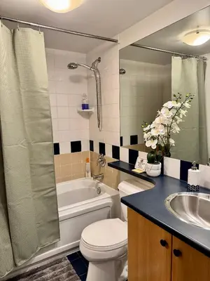a bathroom with a toilet and a tub and a sink at Stylish Two-Story Loft with Rooftop Deck in Vancouver