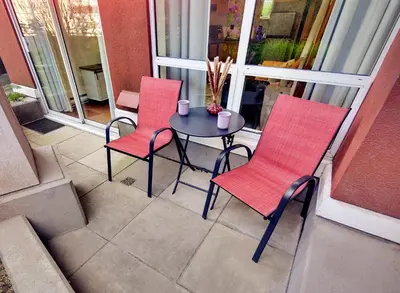 two red chairs and a table on a balcony at Stylish Two-Story Loft with Rooftop Deck in Vancouver