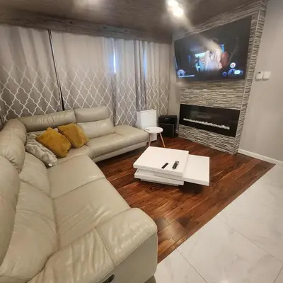 a living room with a couch and a flat screen tv at Modern Family Home with guest heat garage, Pet-Friendly!- NO BASEMENT in Edmonton