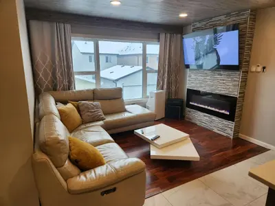 a living room with a couch and a flat screen tv at Modern Family Home with guest heat garage, Pet-Friendly!- NO BASEMENT in Edmonton