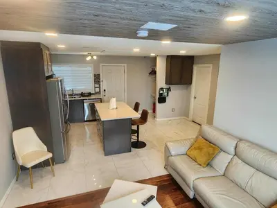 a living room with a couch and a kitchen at Modern Family Home with guest heat garage, Pet-Friendly!- NO BASEMENT in Edmonton