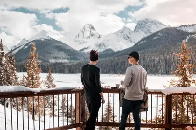two men standing on a deck looking at the mountains at Mount Engadine Lodge in Kananaskis Village