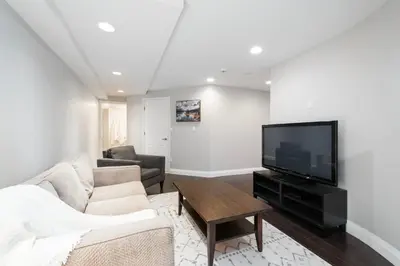a living room with a couch and a flat screen tv at Elegant and Roomy Forest Getaway in North Vancouver