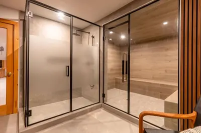 a walk in shower with glass doors at Alders Chalet by Fernie Central Reservations in Fernie