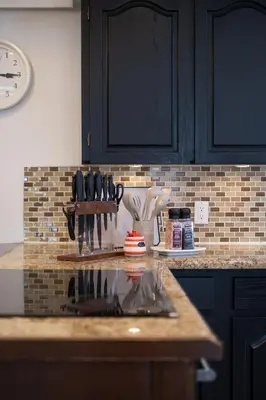 a kitchen with black cabinets and a counter with utensils at 3BR Near Commercial Dr 10 min to Downtown in Vancouver