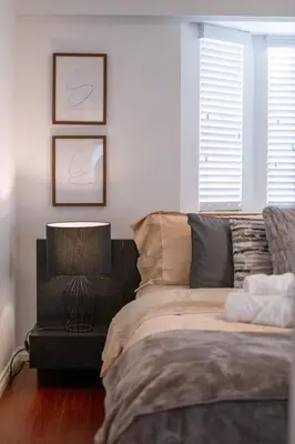 a bedroom with a bed and a table with a lamp at 3BR Near Commercial Dr 10 min to Downtown in Vancouver