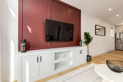 a living room with a flat screen tv on a wall at Perfect for Long Stays Free Parking Pets Allowed in Calgary