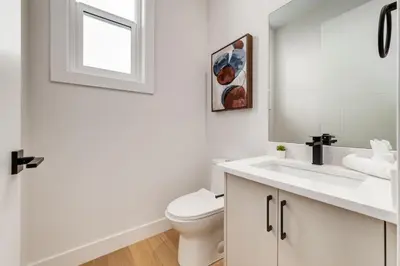 a white bathroom with a toilet and a sink at Long Stays, Pets Welcome, Free Parking & King Bed in Calgary