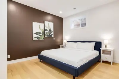 a bedroom with a bed and two pictures on the wall at Long Stays, Pets Welcome, Free Parking & King Bed in Calgary
