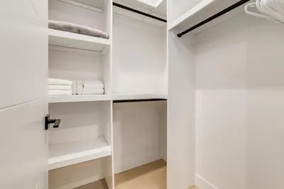 a white walk in closet with white towels at Free Parking, Perfect Family Home with King Bed in Calgary