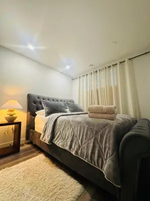 a bedroom with a large bed and a couch at Comfy Neutral Living Free Parking in Calgary