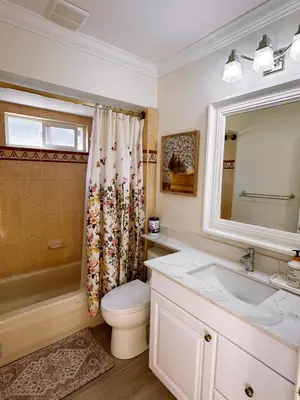 a bathroom with a toilet and a sink and a mirror at Elmshade Villa in Vancouver South in Vancouver