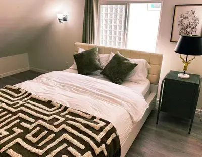 a bedroom with a large bed with pillows on it at Elmshade Villa in Vancouver South in Vancouver