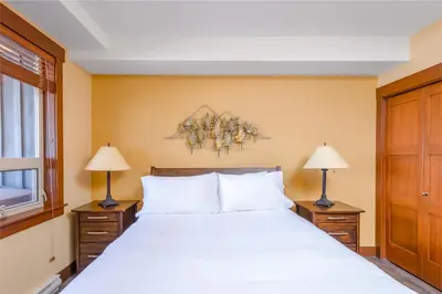 a bedroom with a large bed and two lamps at Stonegate Resort Unit C105 in Kelowna