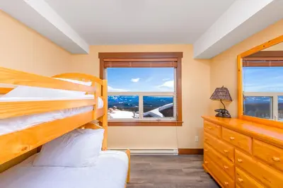 a bedroom with two bunk beds and a window at Stonegate Resort Unit C105 in Kelowna