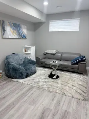 a living room with a couch and a ottoman at 2 Bedroom Basement Suite in Edmonton