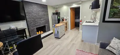 a kitchen and a living room with a fireplace at 1 block to Kelowna General Hospital 2 blocks to Beach 1km to OUC 1km to Downtown Kelowna 20min to YLW in Kelowna