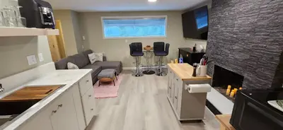 a kitchen and living room with a couch and a fireplace at 1 block to Kelowna General Hospital 2 blocks to Beach 1km to OUC 1km to Downtown Kelowna 20min to YLW in Kelowna