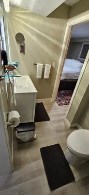 a bathroom with a sink and a toilet and a bed at 1 block to Kelowna General Hospital 2 blocks to Beach 1km to OUC 1km to Downtown Kelowna 20min to YLW in Kelowna