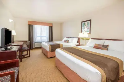 a hotel room with two beds and a television at Gold Circle Inn in Lloydminster