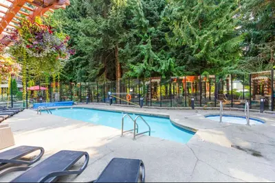 a swimming pool in a park with a fence at Ideal Central Village Location! in Whistler