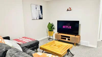 a living room with a couch and a flat screen tv at Tee's Oasis in Calgary