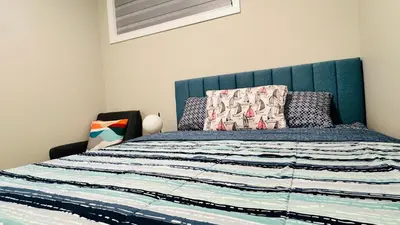 a bed with a blue headboard in a bedroom at Tee's Oasis in Calgary