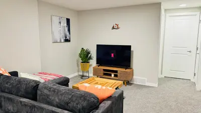 a living room with two couches and a flat screen tv at Tee's Oasis in Calgary