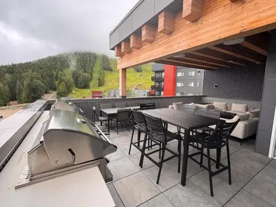 a patio with a table and chairs and a grill at RED Mountain Gem in Trail