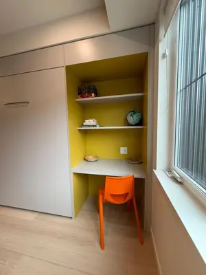 a small orange chair sits in a room with a window at Premium RED Mountain Lodging in Trail