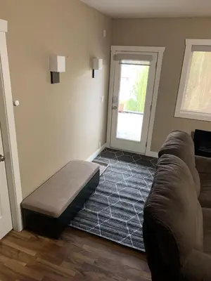 a living room with a couch and a window at Licensed 2-Bedroom Suite Eco-Friendly Solar Home in Kelowna