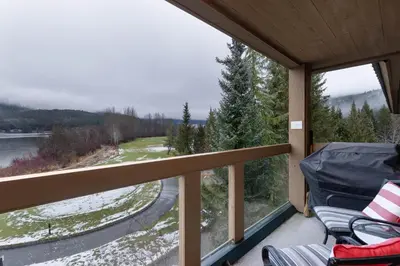 a screened porch with a view of a river and trees at Nicklaus North - Clubhouse by Whistler Premier in Whistler