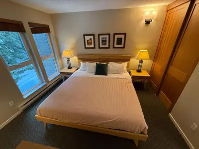 a bedroom with a large bed with two tables and two lamps at Tantalus Lodge by Elevate Vacations in Whistler