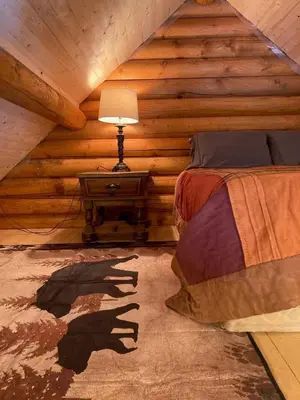a bedroom with a bed in a log cabin at Log lofted rustic cabin in woods in Kelowna