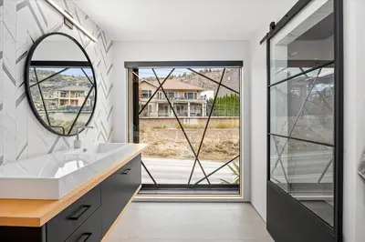 a bathroom with a sink and a mirror at Nest Luxury Modern Lake House in Penticton