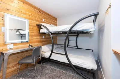 a room with bunk beds and a desk and a chair at Whistler Village Center - Newly Renovated Condo in Whistler